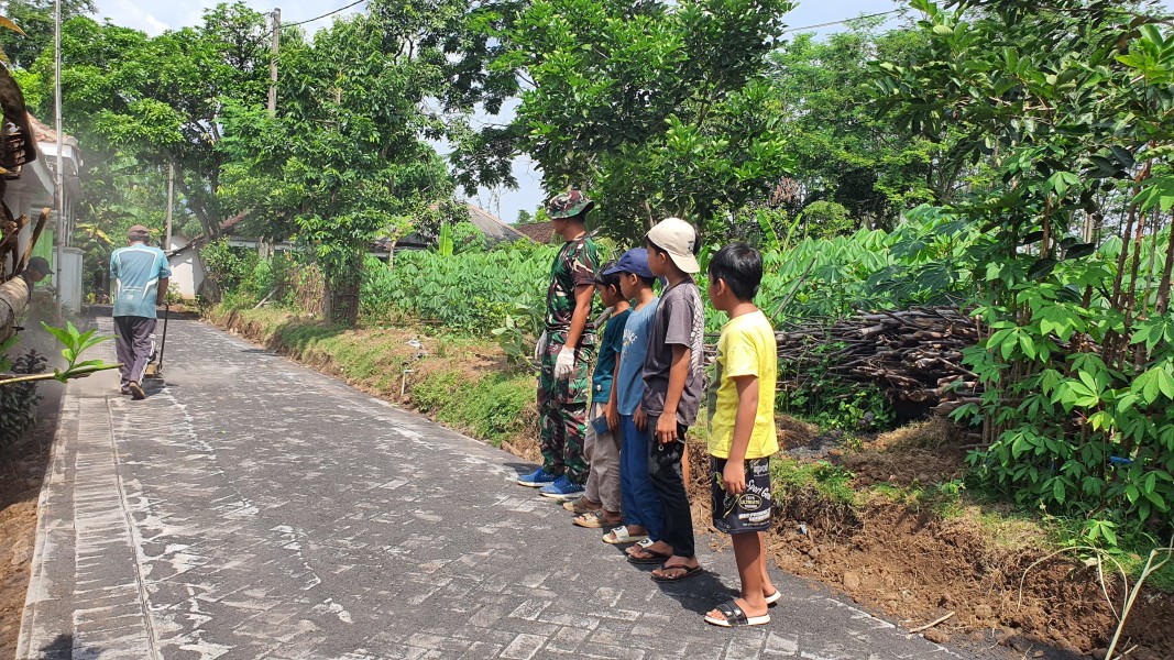 Anak-Anak Antusias Saksikan Pemasangan Paving TMMD Ke-128 di Desa Brabe.