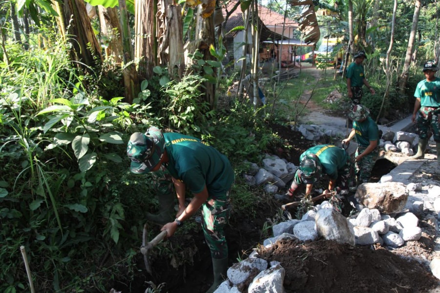 Satgas TMMD ke-129 Kodim 0821/Lumajang Percepat Pembangunan Drainase, Serda Arga Prastu Wiratama Nugraha Turun Langsung Gali Tanah