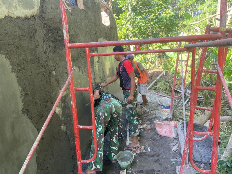 Lanjutkan Pekerjaan Fisik, Satgas TMMD Ke-128 Plester Dinding Musholla Baiturrahim