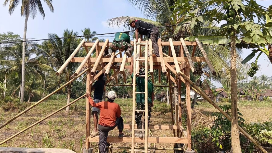 Perkuat Keamanan Lingkungan, Sertu Yoga Pratama Bersama Anggota Bantu Warga Bangun Pos Kamling.