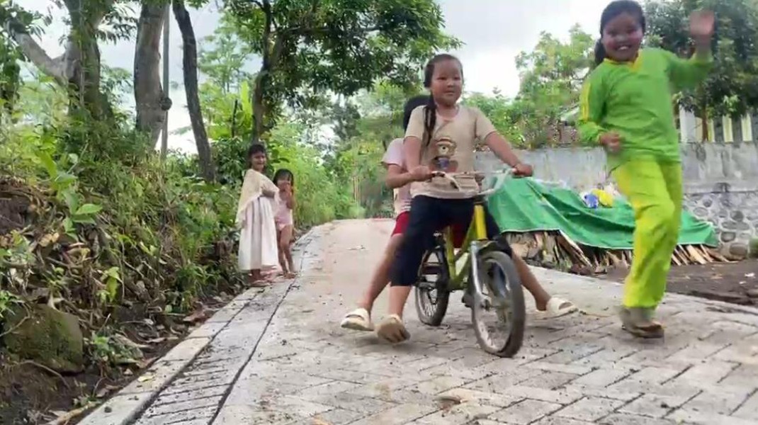 Keceriaan Anak Dusun Klagin Bersepeda di Atas Paving Baru TMMD Ke-128 yang Rampung 100 Persen