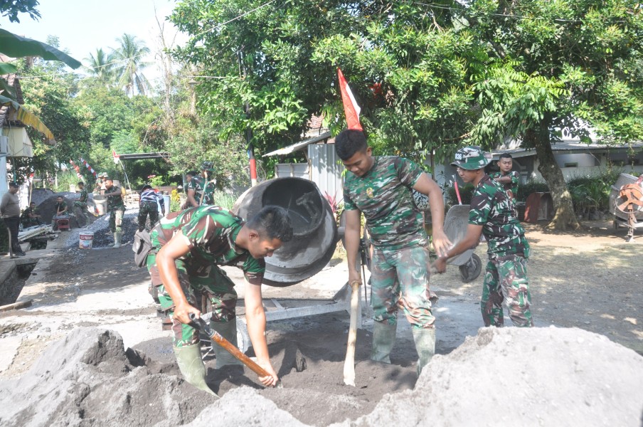 Gemuruh Mesin Molen Iringi Semangat Satgas TMMD, Prada Bintang Dwi Putra Laksanakan Pengecoran Rabat Beton