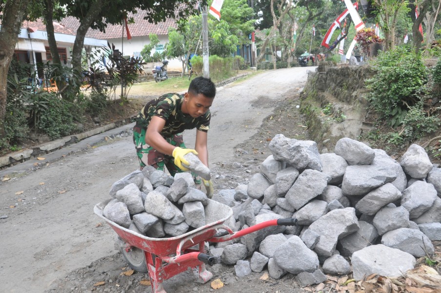 Angkut Batu Demi Percepat Pembangunan Drainase, Prada Teguh Arfianto Warga Segera Rasakan Manfaatnya