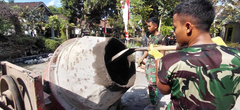 Prada Rio Pamungkas Operasikan Molen, Satgas TMMD Ke-129 Kodim 0821/Lumajang Percepat Pengecoran Rabat Beton